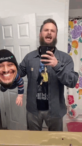 a man wearing a cultivars hat takes a selfie with his phone