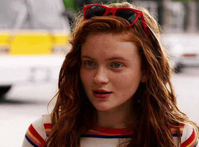a close up of a woman wearing red sunglasses