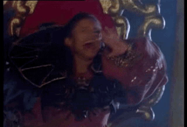 a woman is sitting on a throne and making a peace sign