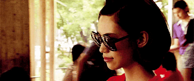 a woman wearing sunglasses looks to the side