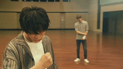 a man in a striped shirt is standing next to another man in a white shirt