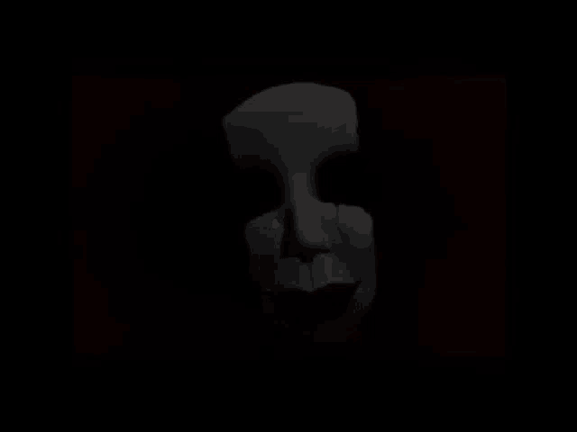 a close up of a scary mask in the dark