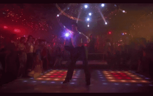 a man is dancing on a disco floor in front of a crowd of people