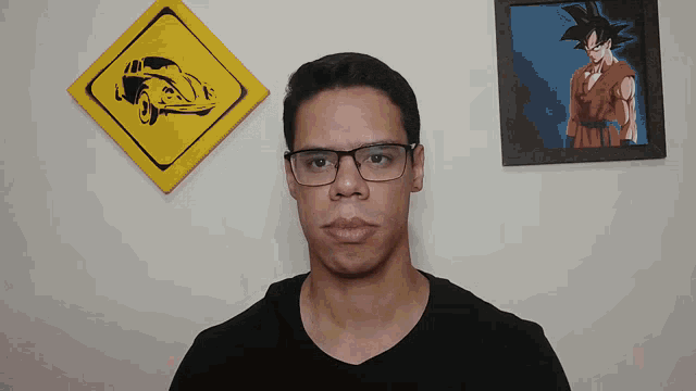 a man wearing glasses stands in front of a painting of a car