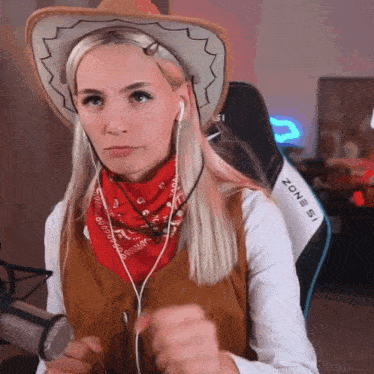 a woman wearing a cowboy hat and a bandana is sitting in a chair that says zone 51