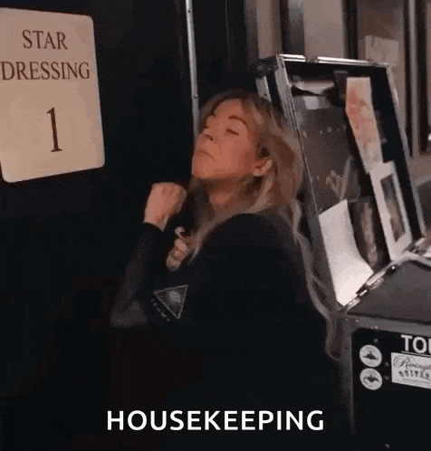 a woman is standing in front of a sign that says star dressing 1 and a box that says housekeeping .