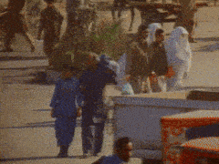 a blurry photo of people walking down a street with a sign that says ' a ' on it