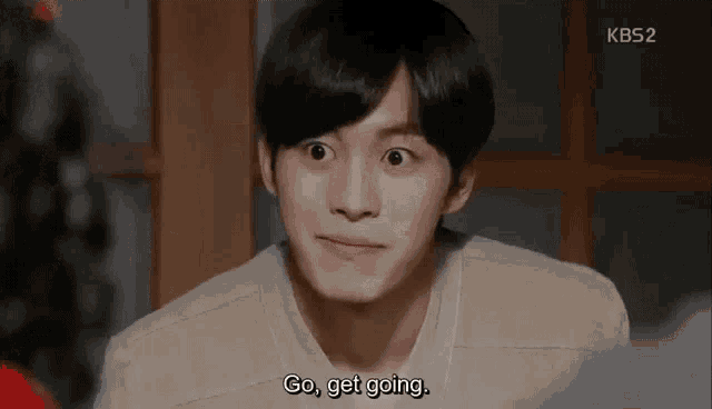 a young man is making a funny face and saying `` go , get going . ''