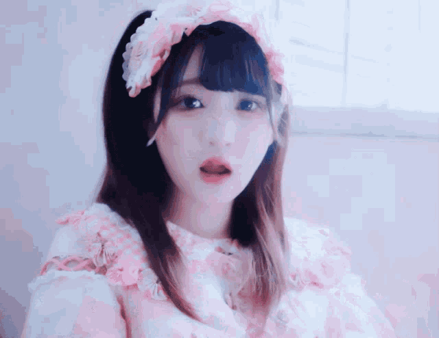a girl is wearing a pink and white dress and a headband with flowers on it