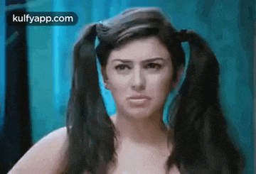 a woman with pigtails is looking at the camera .