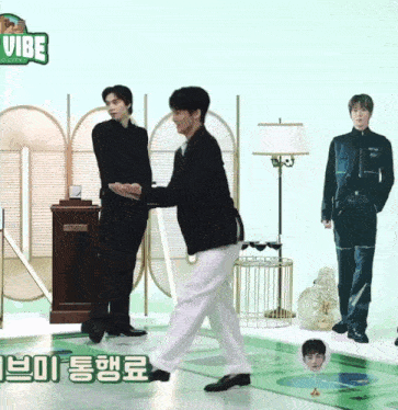 two men are standing next to each other in front of a sign that says vibe on it