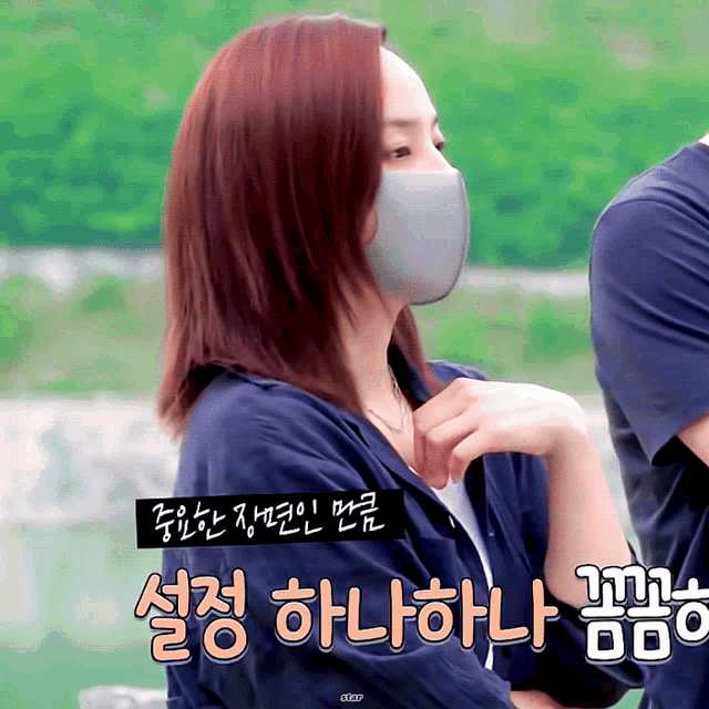 a woman wearing a face mask is standing next to a man in a blue shirt