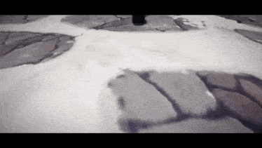 a person is standing in the snow on a rocky surface