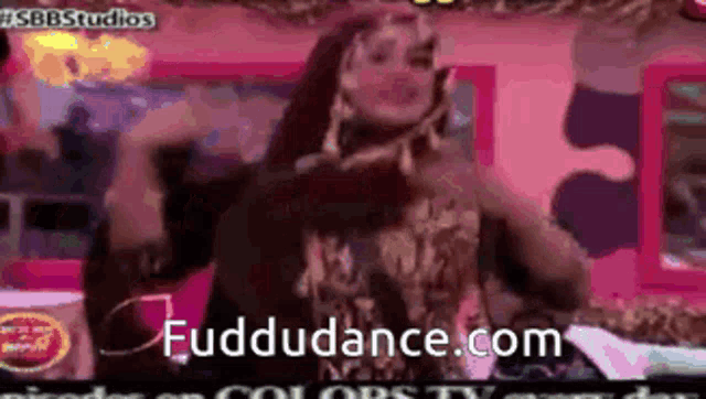 a woman is dancing in front of a screen that says fuddudance.com on it