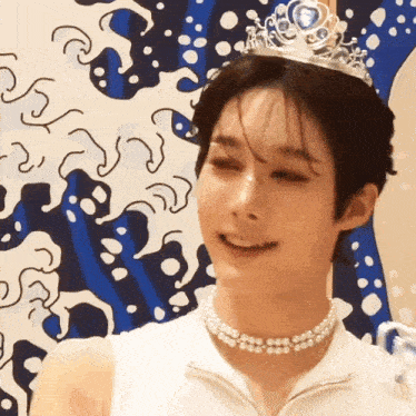 a young man wearing a tiara and pearls smiles