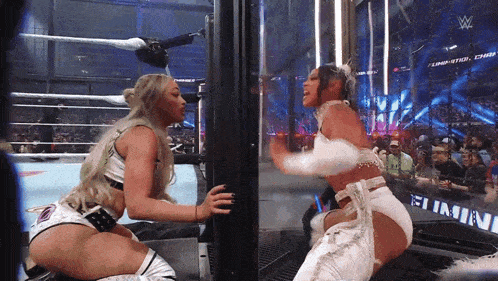 two women wrestling in a ring with a sign that says elimination
