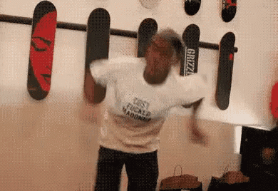 a man is standing in front of a wall with skateboards hanging on it including one that says grizzly
