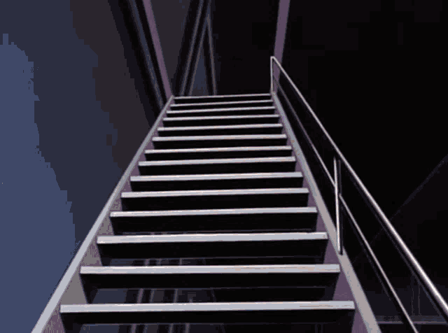 a set of stairs with a metal railing going up to the top