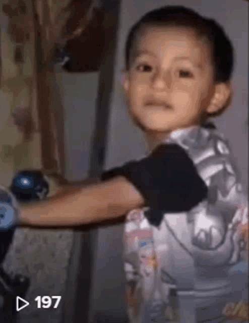 a young boy is playing with a toy car in a video .