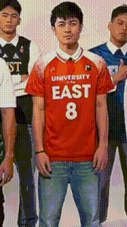 a man in a university east 8 jersey stands in front of a group of people
