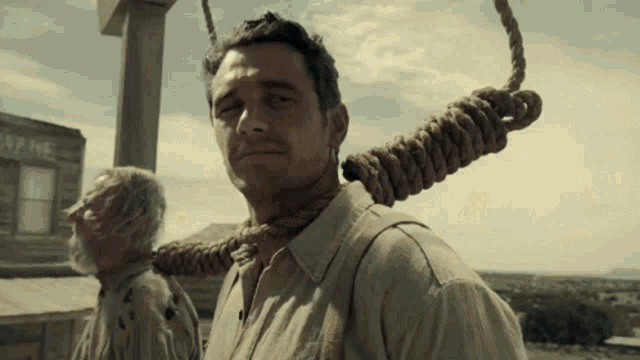 a man with a rope around his neck is standing in front of a building that says fame
