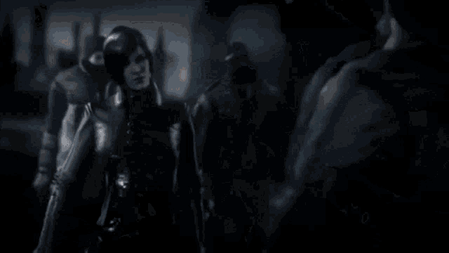 a man is holding a gun and a woman is holding a gun in a dark room .