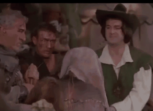 a group of men in medieval costumes are standing next to each other in a room .