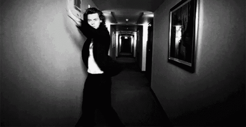 a man in a suit is standing in a hallway with his arms outstretched