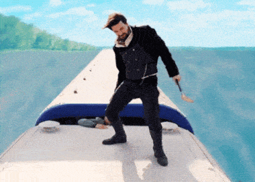 a man is standing on the roof of a boat holding a sword