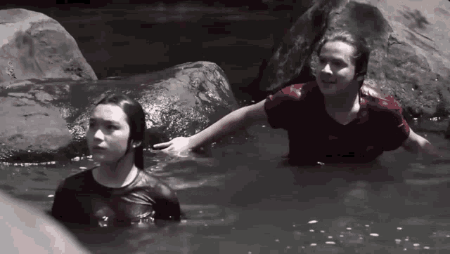 two people in red shirts are in the water