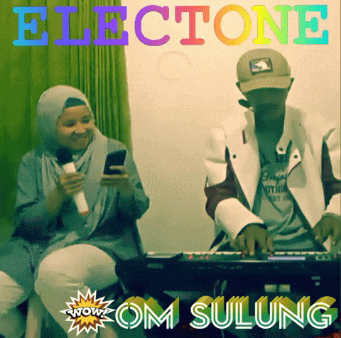 a woman sitting next to a man playing a keyboard with the words " om sulung " on the bottom right