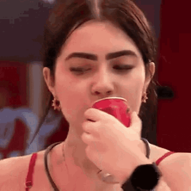 a woman is drinking out of a red cup .