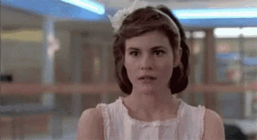 a woman in a white dress and headband is looking at the camera .