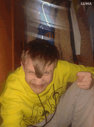 a boy wearing a yellow sweatshirt with the word luma on it