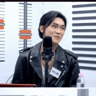 a man wearing a leather jacket has a name tag that says hyun on it