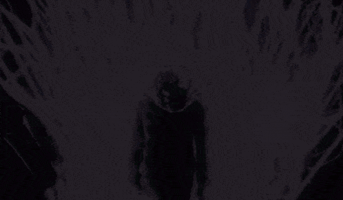 a person is standing in a dark room with a purple light coming out of the ceiling .