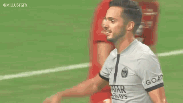 a soccer player wearing a qatar shirt salutes the crowd