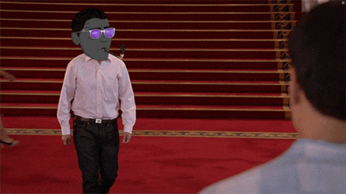 a man wearing sunglasses stands on a red carpet in front of stairs