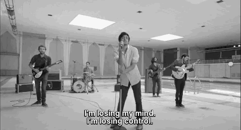 a black and white photo of a band playing instruments in a room .