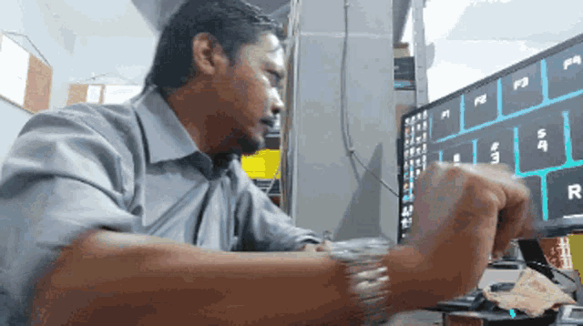 a man sits at a desk in front of a computer with the letters f3 and f4 on the screen