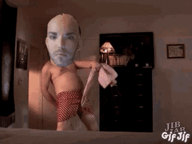 a man without a shirt is standing on a bed with jib tab gif jif written in the corner