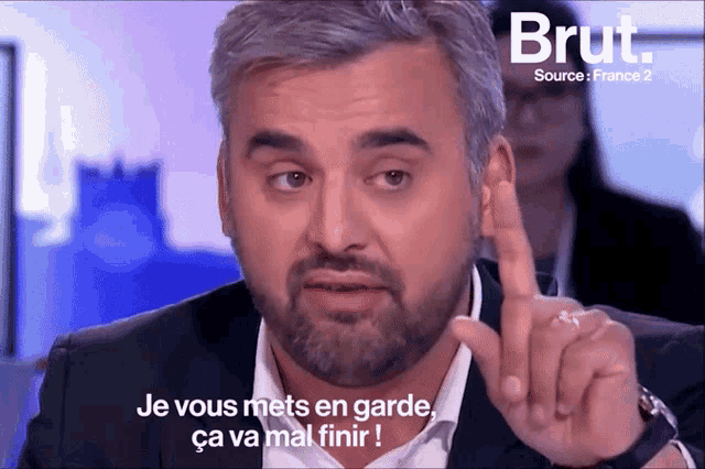 a man with a beard is pointing at something with the words je vous mets en garde ca va mal finir written below him
