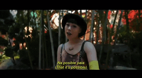 a woman in a black hat is talking to a man in a forest .