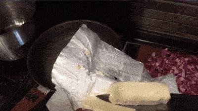 a knife is cutting a piece of butter in a pan
