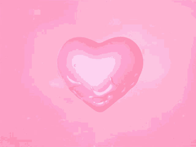 a pink heart shaped object is melting on a pink surface