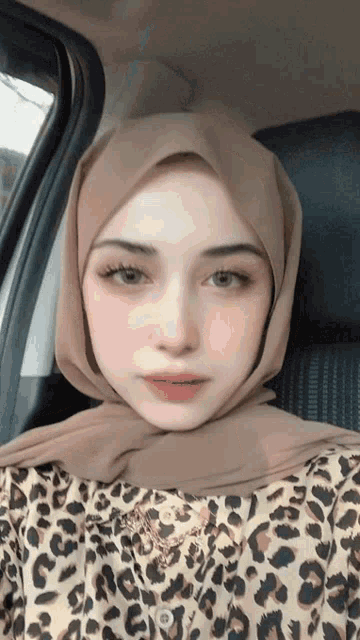 a woman wearing a hijab and a leopard print shirt
