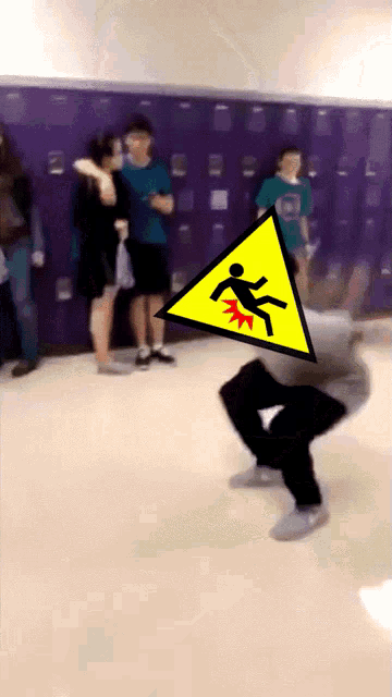 a yellow warning sign with a man falling on it