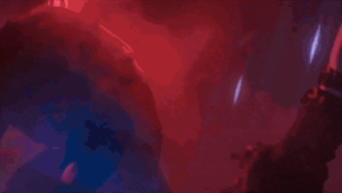 a close up of a person holding a sword in a dark room