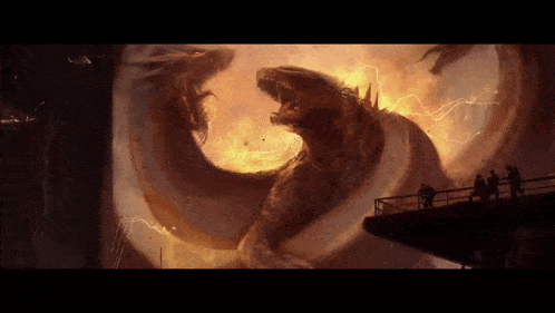 a group of people are standing on a bridge watching a monster attack a city .
