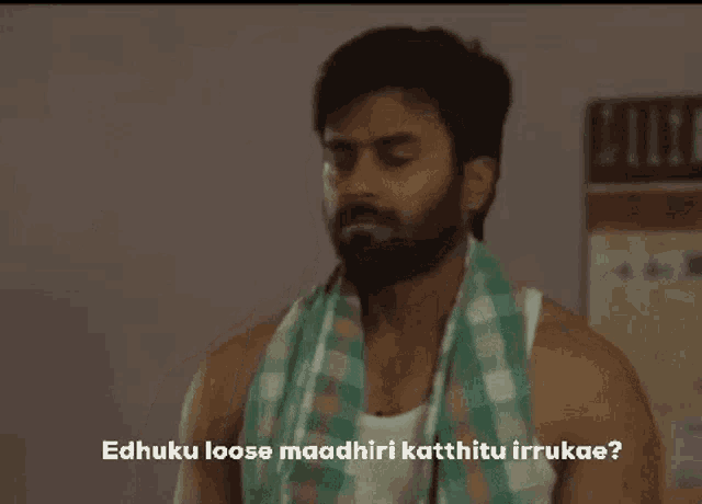 a man with a beard and a towel around his neck is talking to another man .